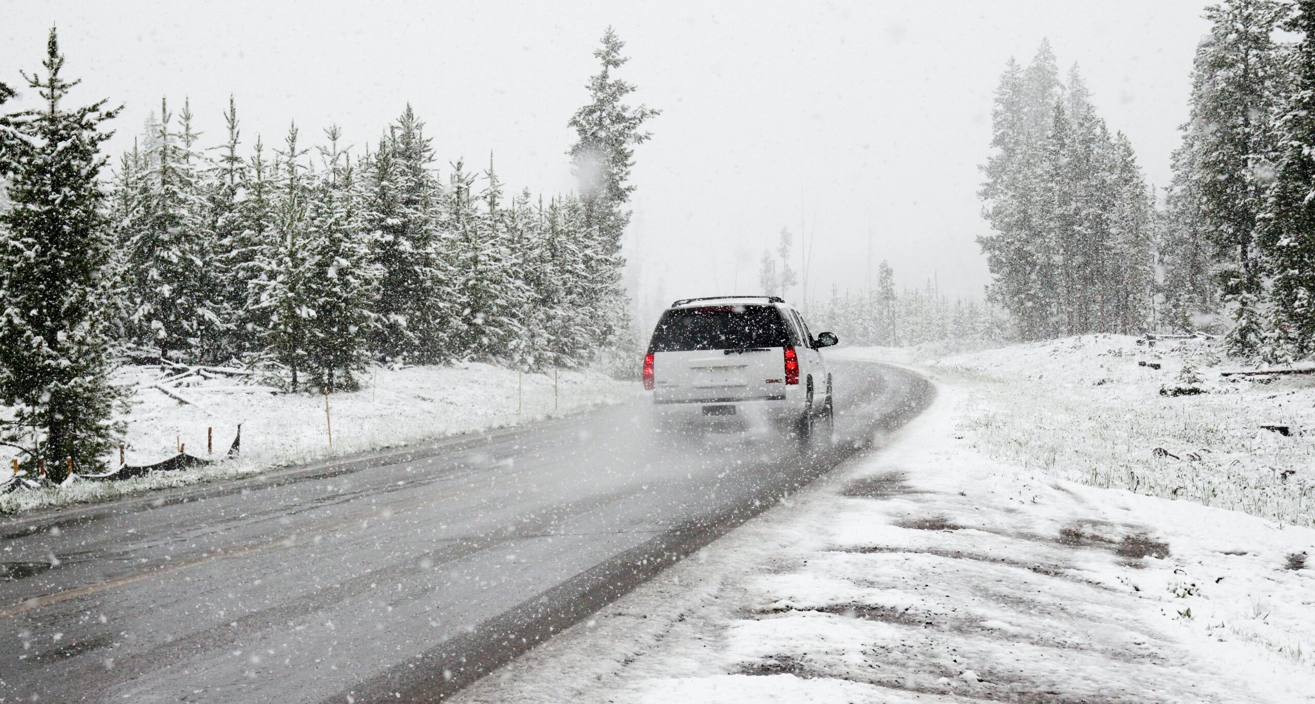 Furgoneta conduciendo por un camino con nieve por los lados transportando mercancía delicada al calor mantenida por el frío de la furgoneta gracias al funcionamiento de las furgonetas frigoríficas